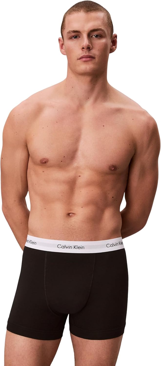 Modello indossa boxer Calvin Klein uomo nero con iconica fascia elastica bianca e logo nero.