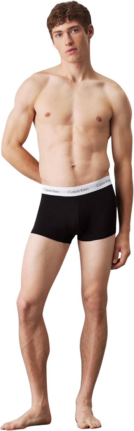 Tre boxer uomo Calvin Klein nei colori nero, grigio e bianco piegati e ordinati.