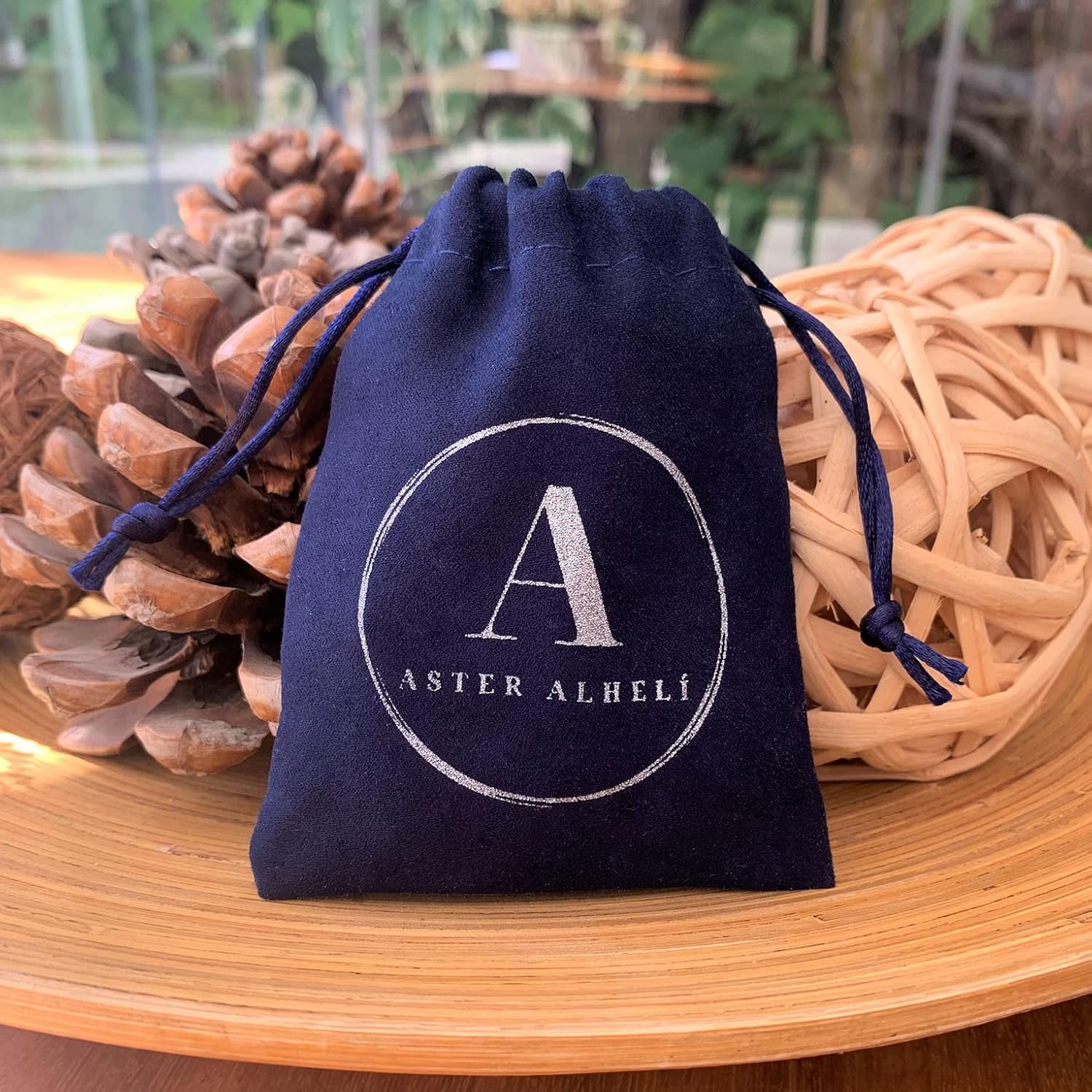 Portachiavi personalizzato con lettere dell'alfabeto e perline d'argento su sfondo neutro.